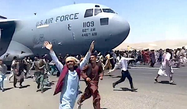 People cling to a U.S. Air Force jet in Kabul, Afghanistan, on Monday, Aug. 16, 2021. (Video screenshot)