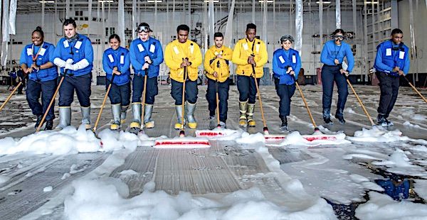 Sailors assigned to Air Department on the aircraft carrier USS George H. W. Bush clean the hangar bay after testing the firefighting system in the hangar bay during Sea Trials in the Atlantic Ocean, Aug. 27, 2021. (U.S. Navy photo by Mass Communication Specialist 3rd Class Ryan Pitt)