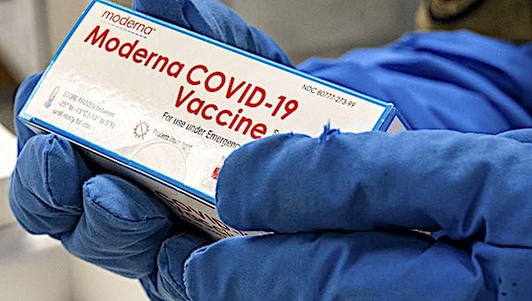 Air Force Staff Sgt. Daniel Monzon-Kazhe holds a box of Moderna COVID-19 vaccines at Yokota Air Base, Japan, Dec. 26, 2020. The 374th Medical Group received 800 doses as its first wave of COVID-19 vaccine shipments. (U.S. Air Force photo by Staff Sgt. Gabrielle Spalding)
