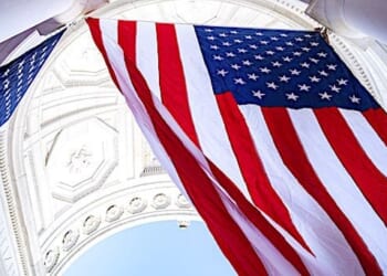 Employees hang U.S. flags in the Memorial Amphitheater at Arlington National Cemetery, Virginia, Nov. 4, 2019, in preparation for Veterans Day. (U.S. Army photo by Elizabeth Fraser)