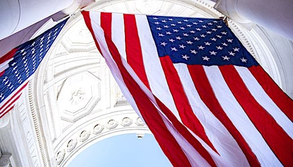 Employees hang U.S. flags in the Memorial Amphitheater at Arlington National Cemetery, Virginia, Nov. 4, 2019, in preparation for Veterans Day. (U.S. Army photo by Elizabeth Fraser)