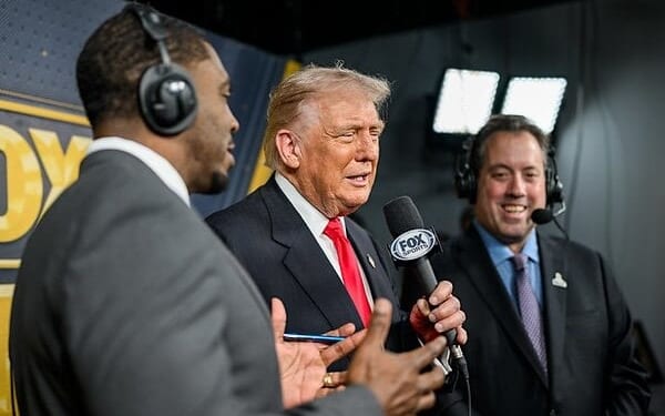 President Donald Trump calls the game alongside Kenny Albert and Jonathan Vilma in the Fox NFL broadcast booth as the Washington Commanders take on the Detroit Lions at Northwest Stadium in Landover, Maryland, Sunday, Nov. 9, 2025. (Official White House photo by Daniel Torok)