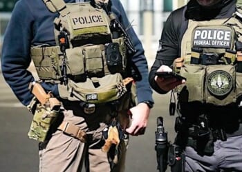 Two federal law enforcement officers coordinate with other officials on the ground during an enhanced immigration enforcement operation near Washington, D.C., Feb. 4, 2025. (ICE photo)