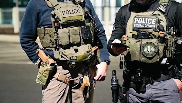 Two federal law enforcement officers coordinate with other officials on the ground during an enhanced immigration enforcement operation near Washington, D.C., Feb. 4, 2025. (ICE photo)