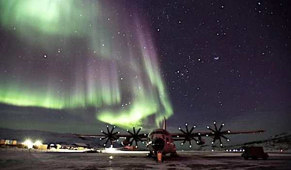 A LC-130 Skibird sits on the ramp at Kangerlussuaq Airport, Greenland, with the Northern Lights dazzling in the sky above, March 14, 2021. (Photo courtesy U.S. Air Force Lt. Col. Kevin Jones)