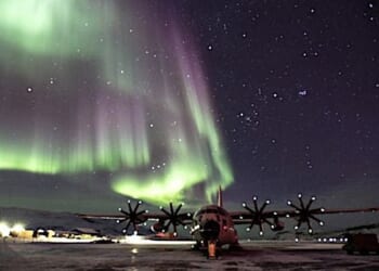 A LC-130 Skibird sits on the ramp at Kangerlussuaq Airport, Greenland, with the Northern Lights dazzling in the sky above, March 14, 2021. (Photo courtesy U.S. Air Force Lt. Col. Kevin Jones)
