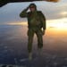 A U.S. soldier assigned to 1st Battalion, 10th Special Forces Group (Airborne) salutes his fellow soldiers while jumping out of a C-130 Hercules aircraft over a drop zone in Germany, Feb. 24, 2015. (U.S. Army photo by Visual Information Specialist Jason Johnston)