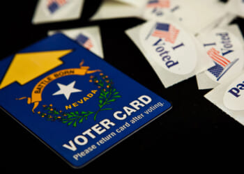 A Nevada voting card surrounded by "I Voted" stickers on a black background.