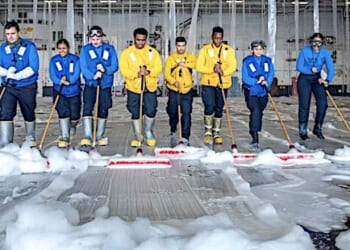 Sailors assigned to Air Department on the aircraft carrier USS George H. W. Bush clean the hangar bay after testing the firefighting system in the hangar bay during Sea Trials in the Atlantic Ocean, Aug. 27, 2021. (U.S. Navy photo by Mass Communication Specialist 3rd Class Ryan Pitt)