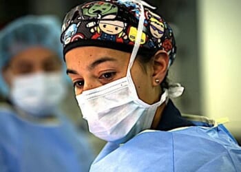 Lt. Cmdr. Marissa Mayor, a general surgeon with Fleet Surgical Team 7, observes her patient prior to conducting a surgical walkthrough during a mass casualty drill to assess skills and coordination between integrated units aboard the amphibious assault ship USS America in the Philippine Sea, June 18, 2021. (U.S. Marine Corps photo by Cpl. Karis Mattingly)