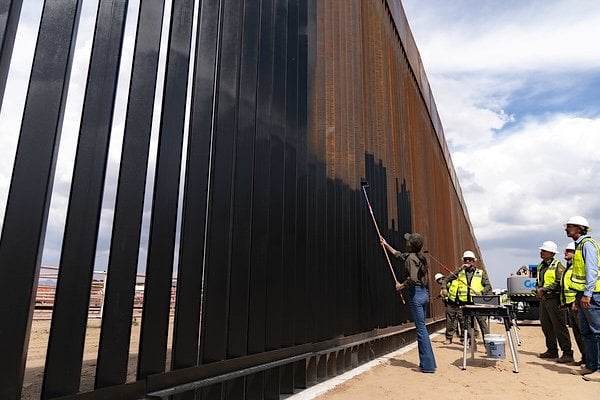 Department of Homeland Security (DHS) Secretary Kristi Noem paints the steel border wall black in Santa Teresa, New Mexico, Tuesday, Aug. 19, 2025. (DHS photo by Tia Dufour)