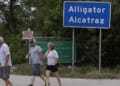 OCHOPEE, FLORIDA - APRIL 22: People walk near the front entrance to the immigration detention center in the Florida Everglades known as “Alligator Alcatraz" on April 22, 2026, in Ochopee, Florida. A federal appeals court overturned an injunction by a district court judge requiring officials to dismantle “Alligator Alcatraz” in response to a lawsuit filed by environmental groups. (Photo by Joe Raedle/Getty Images)
