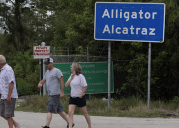 OCHOPEE, FLORIDA - APRIL 22: People walk near the front entrance to the immigration detention center in the Florida Everglades known as “Alligator Alcatraz" on April 22, 2026, in Ochopee, Florida. A federal appeals court overturned an injunction by a district court judge requiring officials to dismantle “Alligator Alcatraz” in response to a lawsuit filed by environmental groups. (Photo by Joe Raedle/Getty Images)