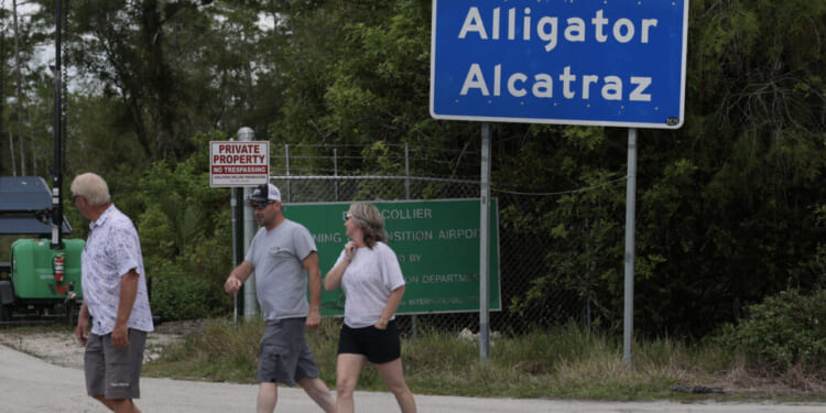 OCHOPEE, FLORIDA - APRIL 22: People walk near the front entrance to the immigration detention center in the Florida Everglades known as “Alligator Alcatraz" on April 22, 2026, in Ochopee, Florida. A federal appeals court overturned an injunction by a district court judge requiring officials to dismantle “Alligator Alcatraz” in response to a lawsuit filed by environmental groups. (Photo by Joe Raedle/Getty Images)