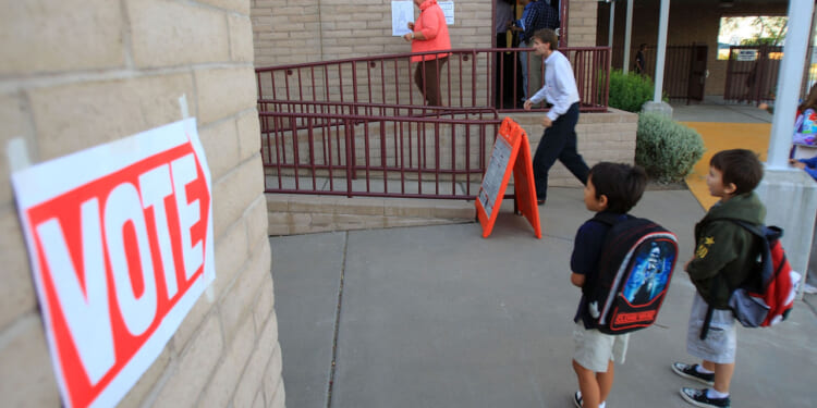 PHOENIX - NOVEMBER 4: Children look at a polling place located at their school in the home state of Republican presidential nominee U.S. Sen. John McCain (R-AZ) November 4, 2008 in Phoenix, Arizona. Voting is underway in the U.S. presidential elections with Democratic presidential nominee Sen. Barack Obama (D-IL) leading in the polls against the Republican presidential nominee Sen. John McCain (R-AZ). (Photo by David McNew/Getty Images)