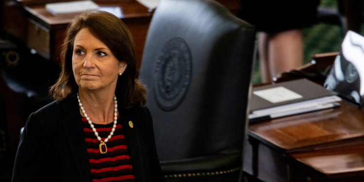 Angela Paxton looks on