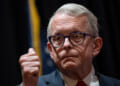 Ohio Gov. Mike DeWine stands with his thumbs up.