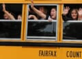 Students waving from a bus that says "Fairfax County"