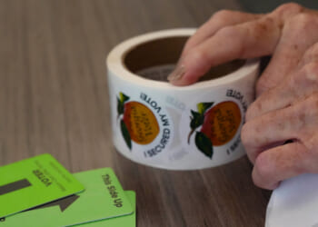 A woman tears stickers on Election Day.