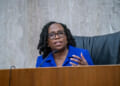Justice Kentanji Brown Jackson gestures as she sits at a dais.