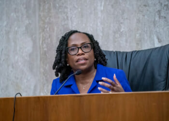 Justice Kentanji Brown Jackson gestures as she sits at a dais.