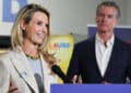 Governor Gavin Newsom looks on as his wife Jennifer Siebel Newsom speaks.