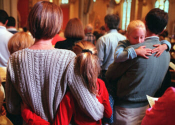 A family holds each other while attending a church service.