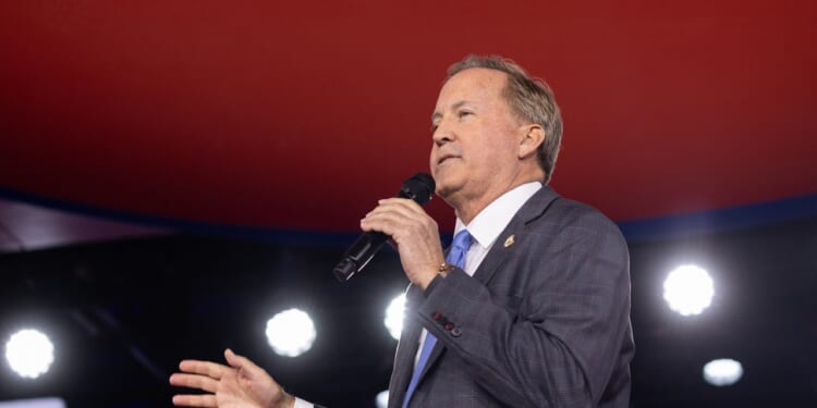 Texas Attorney General Ken Paxton speaking into a microphone