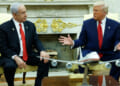 Donald Trump gestures to Benjamin Netanyahu as they sit in the Oval Office.