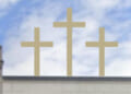 Three golden crosses stand on top of a building.