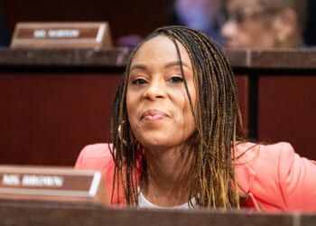 Shontel Brown smiles as she looks ahead while sitting for a committee hearing.