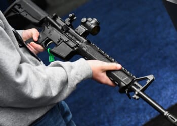 An attendee holds a Springfield Armory SAINT AR-15 style rifle.
