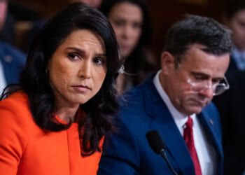 Tulsi Gabbard and John Ratcliffe speak to members of Congress in a hearing.