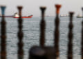 Tankers on the Strait of Hormuz as seen through posts on an Iranian beach.