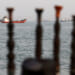 Tankers on the Strait of Hormuz as seen through posts on an Iranian beach.