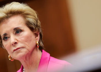 Linda McMahon looks on