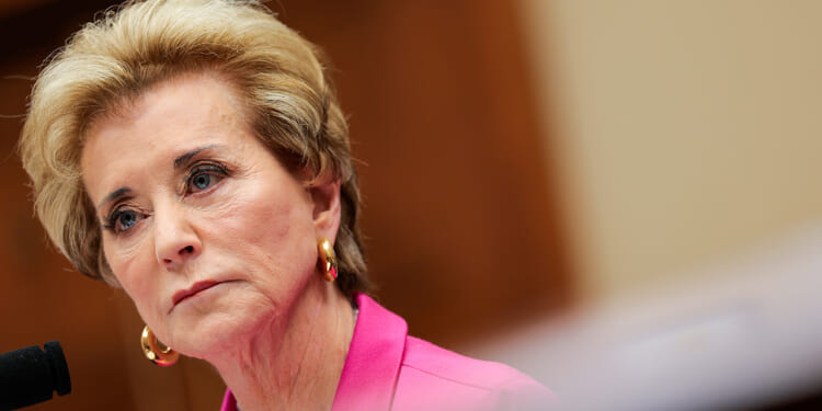 Linda McMahon looks on