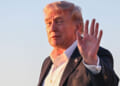 President Donald Trump waves to the press.