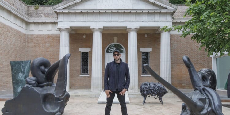 A man standing between two statues