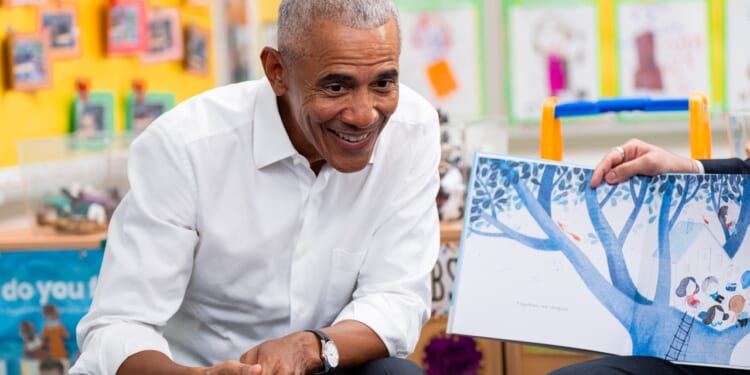 Former President Barack Obama smiling while seated
