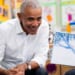 Former President Barack Obama smiling while seated