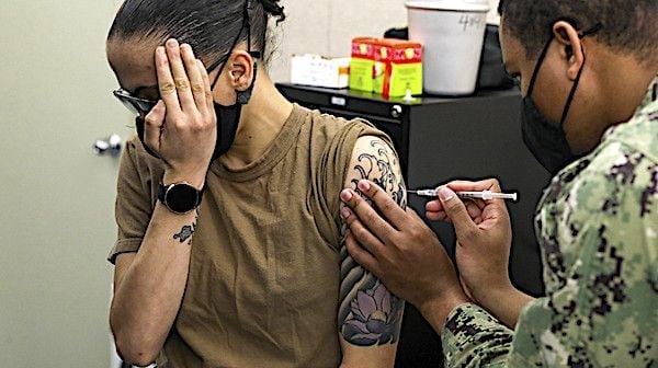 Hospital Corpsman 3rd Class Kyle Massey, assigned to the submarine tender USS Emory S. Land, administers the first dose of the Moderna COVID-19 vaccine to Machinist Mate 3rd Class Brandy Mingus, also assigned to Emory S. Land, at Mare Island Dry Dock, in Vallejo, California, March 18, 2021. (U.S. Navy photo by Mass Communication Specialist 3rd Class Zachary Grooman)