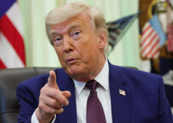President Donald Trump gestures from his desk in the Oval Office.