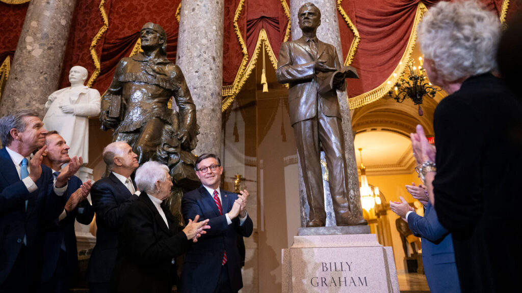 Inside Speaker Johnson’s Private Capitol Tour: Faith and America’s Founding 1 Speaker of the House Mike Johnson (C)(R-LA) and others help unveil a statue of the late US Southern Baptist Minister, Billy Graham, in Statuary Hall at the US Capitol in Washington, DC, on May 16, 2024. Graham was the most widely heard Christian evangelist in history, preaching in person to more than 210 million people worldwide. (Photo by ROBERTO SCHMIDT / AFP) (Photo by ROBERTO SCHMIDT/AFP via Getty Images)