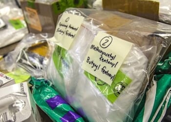 A table full of fentanyl and other designer drugs seized by CBP sit on display at the International Mail Facility in Chicago, Illinois, November 28, 2017, as Illinois Gov. Bruce Rauner is given a tour of CBP operations. (U.S. Customs and Border Protection photo by Kris Grogan)