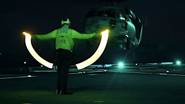 Aviation Boatswain's Mate (Handling) Airman Ethan Bowser directs an MH-60S Sea Hawk from Helicopter Sea Combat Squadron 23 aboard expeditionary sea base USS Miguel Keith in the Pacific Ocean, Aug. 11, 2021. (U.S. Navy photo by Mass Communication Specialist 2nd Class Hector Carrera)