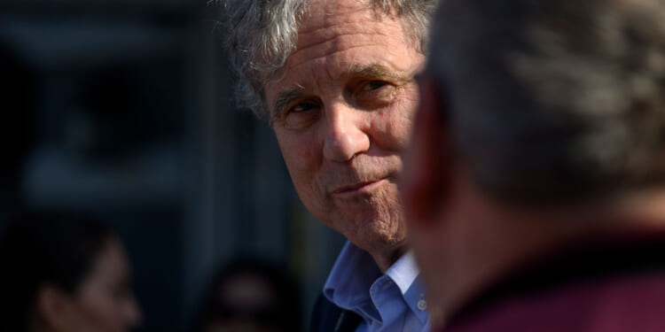 Sherrod Brown, an Ohio Democrat, looks on at another person.