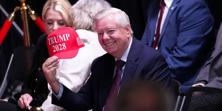 Sen. Lindsey Graham (R-SC) holds up a hat that reads "Trump 2028" during an event at the Kennedy Center on August 13, 2025 in Washington, DC.