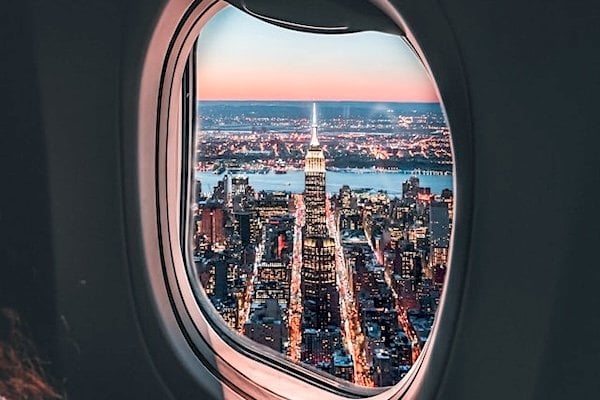 The Empire State Building as seen through the window of an airplane flying above New York City. (Photo by Maximilien T'Scharner on Unsplash)