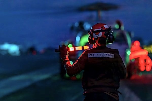 A sailor prepares a Navy MH-60R Sea Hawk to take off from the aircraft carrier USS Abraham Lincoln in U.S. 5th Fleet area of responsibility, Saturday, June 27, 2026. (U.S. Navy photo)